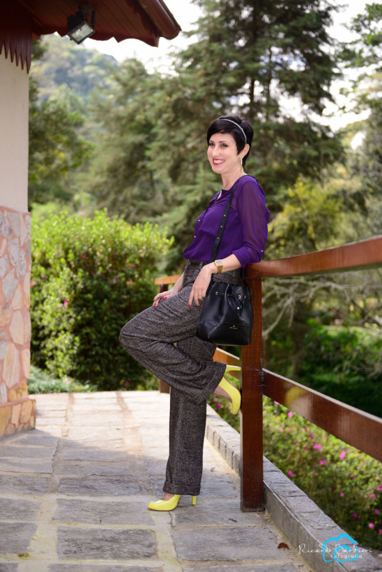 camisa de manga longa roxa, calça de boca mais aberta cinza de lã, scarpin amarelo neon, casacão preto, bolsa saco preta