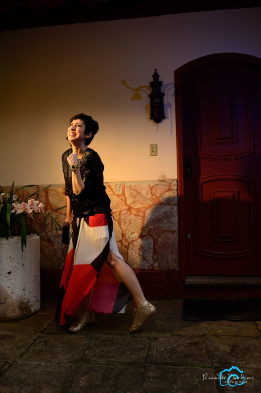 vestido longo plissado com transparência e forro mais curto, nas cores branco, preto, laranja e magenta, tricô preto e colar longo com tênis dourado texturizado