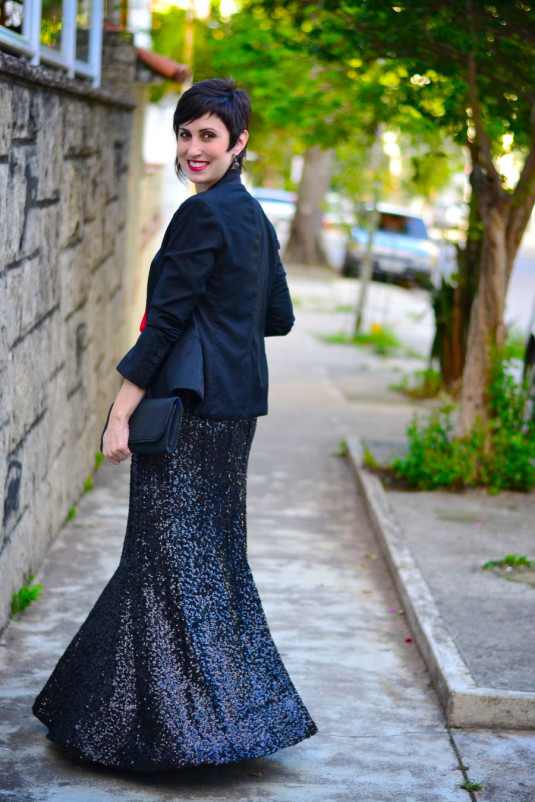 saia longa de paetês preta, regata de cetim vermelha, blazer preto e carteira de neoprene preta